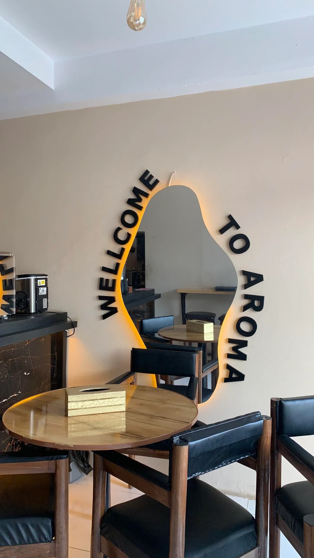 Aroma Cafe interior with the illuminated Welcome to Aroma mirror sign